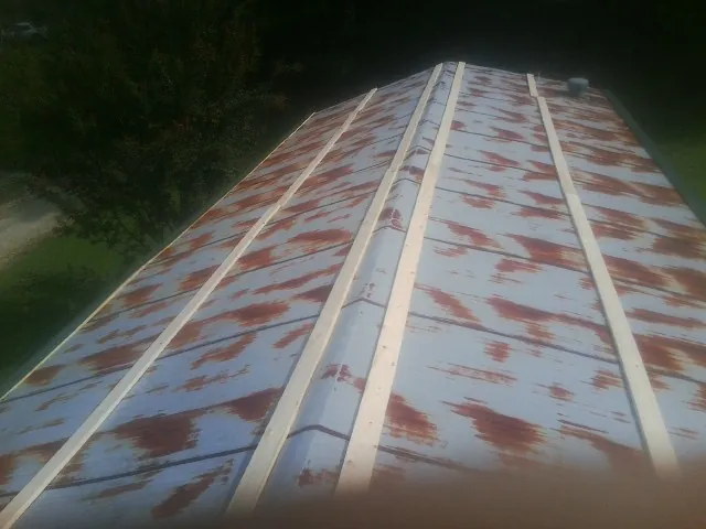 Rusted metal roof panels with new wood purlins before replacement — Storm Damage Roof Repair in Tilton by Roofing Brothers
