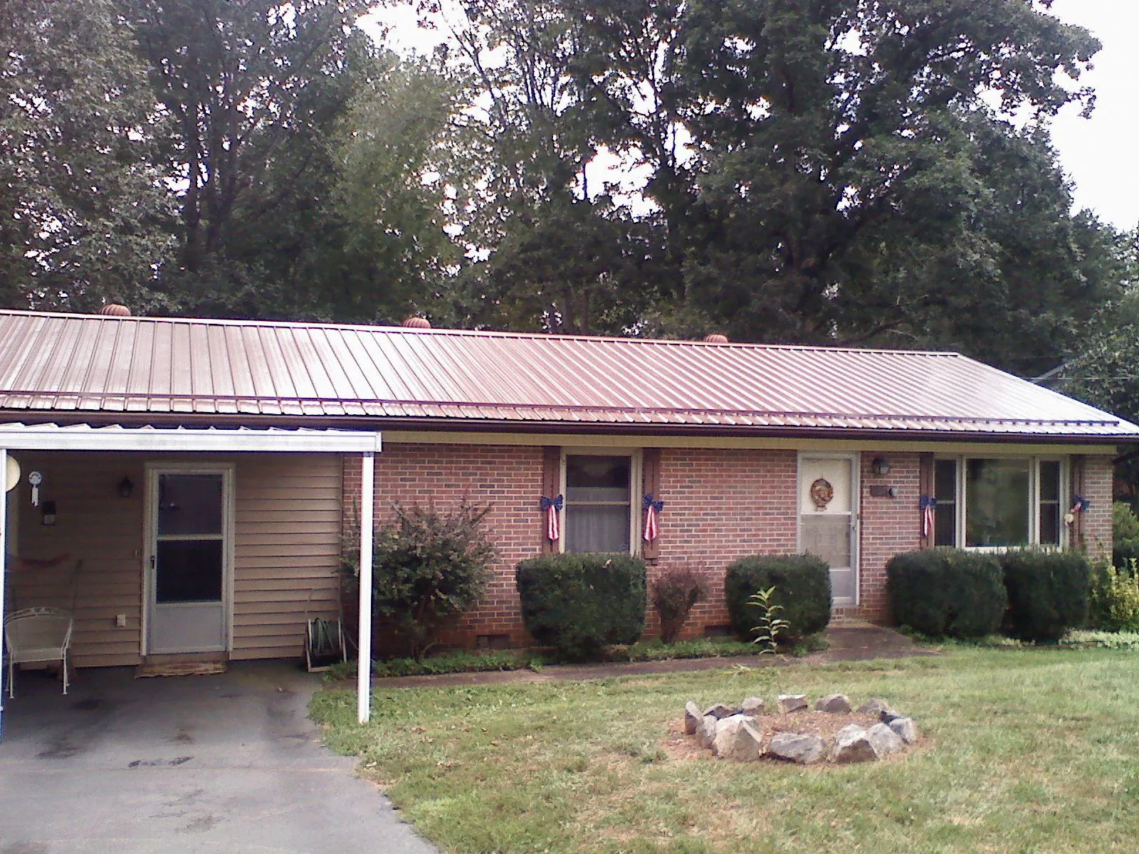 Bronze metal roof and carport on a brick ranch home — Roof Repair work by our crew in Tilton