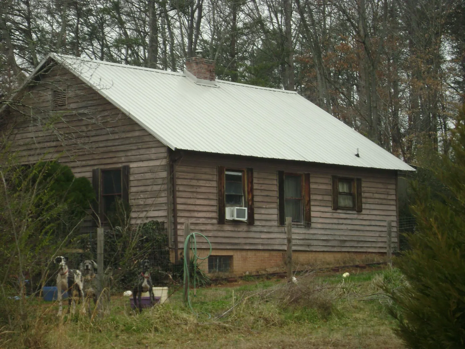 White metal roof on an old wood sided farmhouse, from a Metal Roof Installation job in Tilton